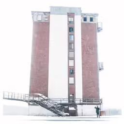 people standing in the snow by the side of an old building