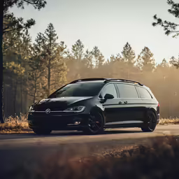 a black volkswagen wagon wagon parked in the middle of a road