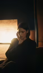a woman sitting on a couch looking at a cellphone
