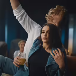 a man in a white shirt and a woman in a black top are looking at something with their hands on their hips
