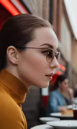 a woman with a ponytail wearing sunglasses looks away from the camera