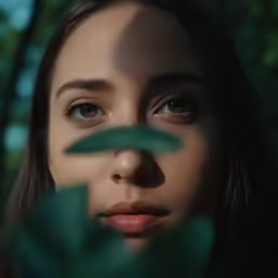 a girl with green leaves and a blue eyes is shown from the outside
