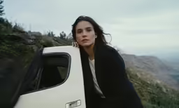 woman leaning up against the back of an old pick up truck