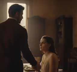 a woman standing next to a man in a living room