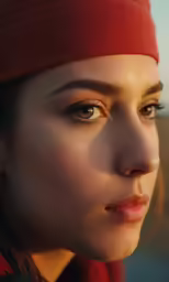 a woman is wearing a red head band and a hat