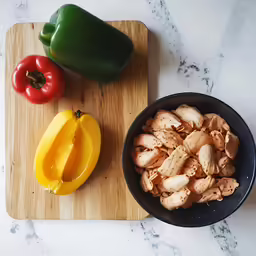 a cutting board topped with a peppers and sliced bell pepper
