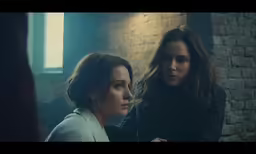 two women looking out from a dark room