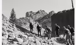 some people in uniform climbing up a mountain