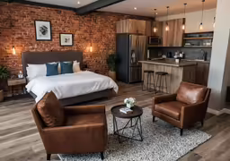 a modern bedroom with brick wall and kitchen