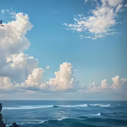a plane flies high up above a blue ocean