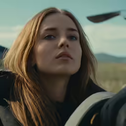 a woman in black jacket with mountains in the background