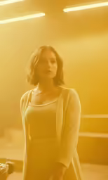 a woman standing in a room with a yellow light