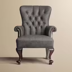 a gray chair that is next to a beige wall