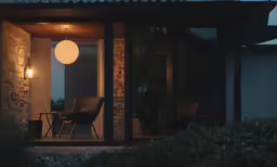 a small patio with a table and chairs at night