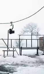 a couple of benches in front of a snow covered park