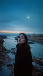 a woman is looking off into the distance in front of a body of water
