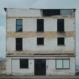 an old white brick building with black doors
