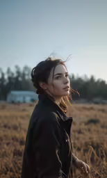 a girl standing in an open field with some kind of hair