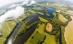 a body of water surrounded by lush green fields