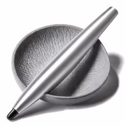 a pen is on top of a plate with silver finish