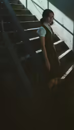 a young woman standing on some stairs with her hands on the handrail