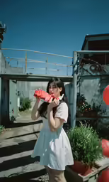 a young woman is holding up a piece of tissue
