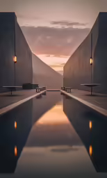 long reflecting pool with benches next to it at sunset