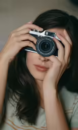 girl holding up camera in both hands to take pictures