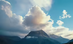 a mountain that has some clouds in it