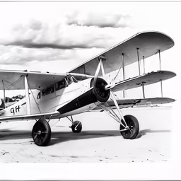 a small plane parked on a runway next to a field