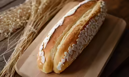 a bread on a wooden cutting board sits on a table