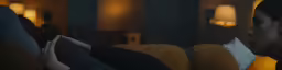 a girl sitting on the couch is holding something
