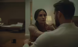 a woman and a man sitting at a table in a bedroom