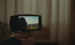 someone is holding a small camera up to take a photo