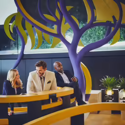 three business people sitting in the lobby having a conversation