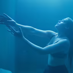 a woman reaching up in the air while diving