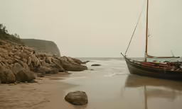 an old boat near a rocky shoreline on a beach