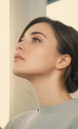 a woman in a gray shirt has her eyes open