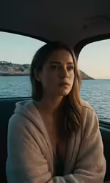 a woman in a car is looking at the camera
