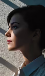 a woman is standing looking out a window