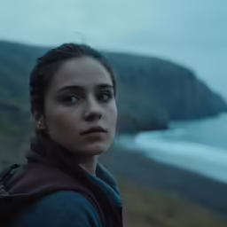 the woman is standing in front of the ocean