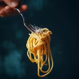 a close up of a fork with some spaghetti