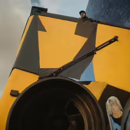 the man is sitting on a yellow piece of art