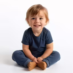 there is a smiling little girl sitting on the floor