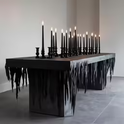 the table has many black candles on it