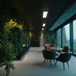 a patio with chairs, plants and tables