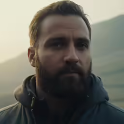 a man with beard looking into the distance