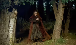 a person standing in the forest holding something