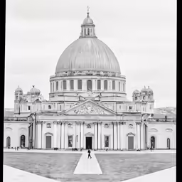 a black and white image of a domed building with two women walking