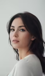 a beautiful young woman with long dark hair and blue eyes